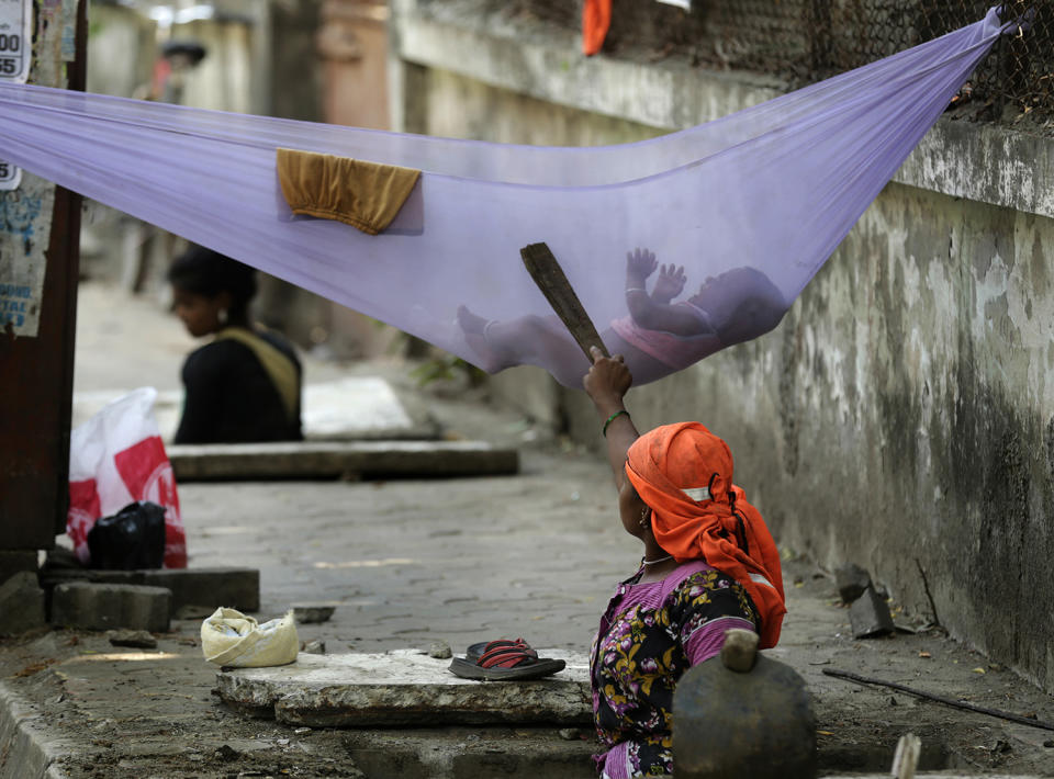 <p>A woman laborer pacifies her child while cleaning a manhole on a sidewalk in Mumbai, India, Monday, May 22, 2017. Some 800 million people in the country live in poverty and many of them migrate to big cities in search of a livelihood. (AP Photo/Rafiq Maqbool) </p>