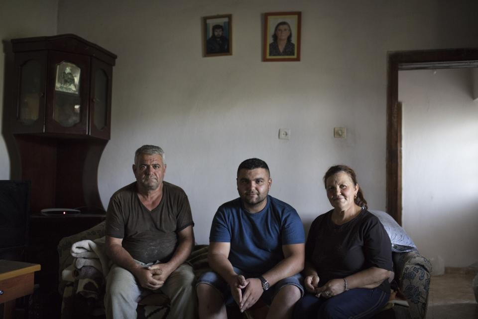 Hekuran Jahaj posa junto a su padre Novruz y su madre Liliana en su casa de Albania. El joven planeaba emigrar a Alemania para trabajar en la construcción, pero la pandemia del coronavirus trastocó sus planes y ahora tendrá que esperar. (Foto: Daniel Cole / AP).