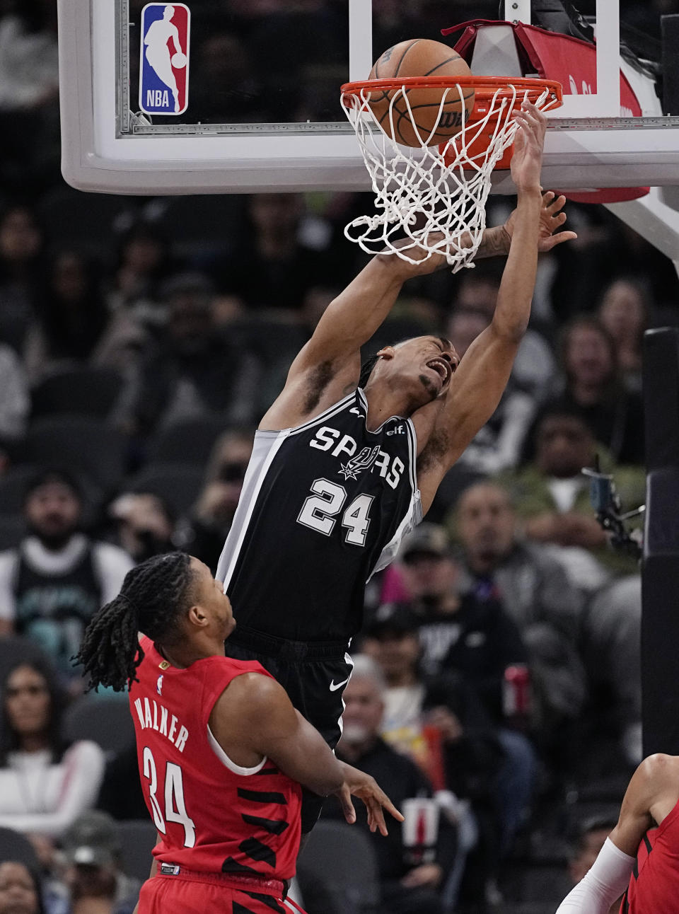 San Antonio Spurs guard Devin Vassell (24) is fouled as he scores over Portland Trail Blazers forward Jabari Walker (34) during the first half of an NBA basketball game in San Antonio, Friday, Jan. 26, 2024. (AP Photo/Eric Gay)