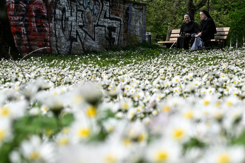 Nuns sit on a bench in a park in the center of Frankfurt am Main, western Germany, on April 17, 2024.