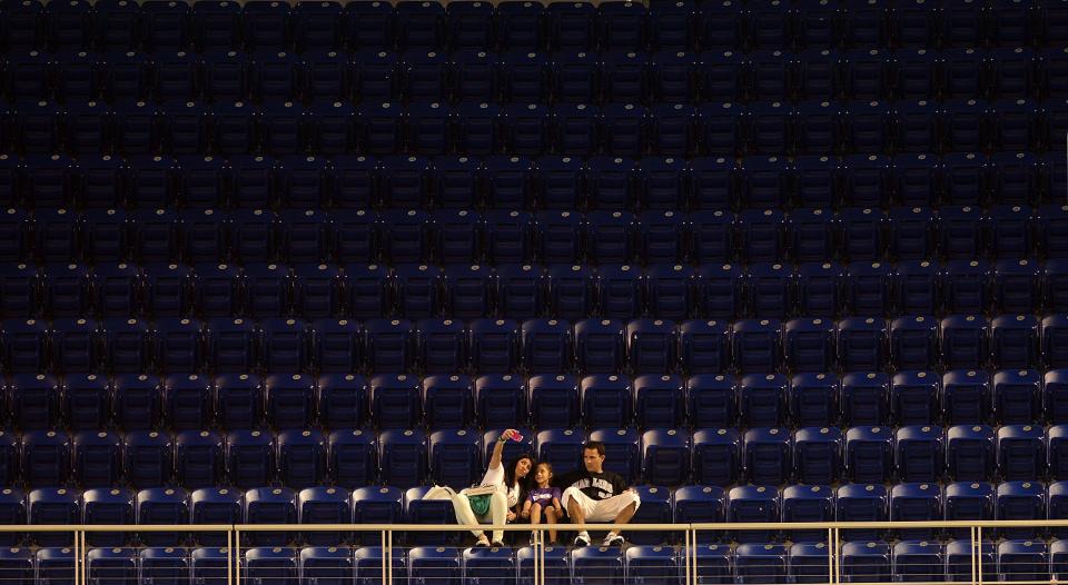 A family sits in an empty section of seats during the Miami Marlins and Philadelphia Phillies game at Marlins Park on April 13, 2013 in Miami, Florida. (Photo by Jason Arnold/Getty Images)