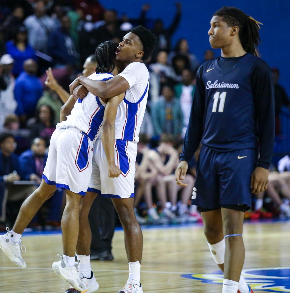Dover's Denim Perkins (left) and Dorell Little embrace in front of Salesianum's Isaiah Hynson late in the second half of Dover's 56-53 win in the DIAA championship at the Bob Carpenter Center, Saturday, March 9, 2024.