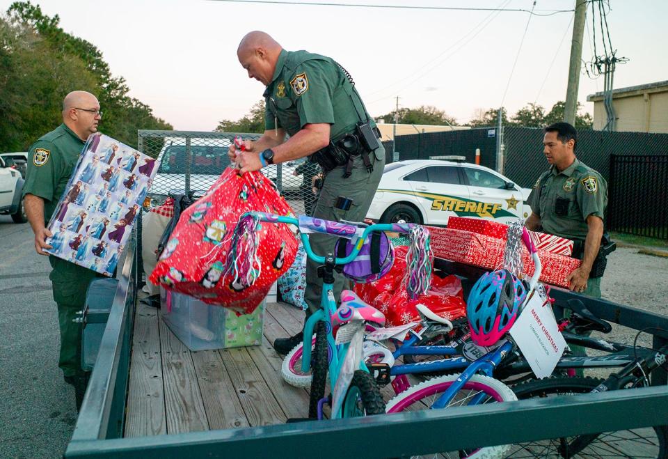 Okaloosa County sheriffs deputies load a trailer with gifts for children at Mary Esther Elementary School during the annual Angel Tree Toy Drive. Close to 300 students will receive Christmas presents this year.