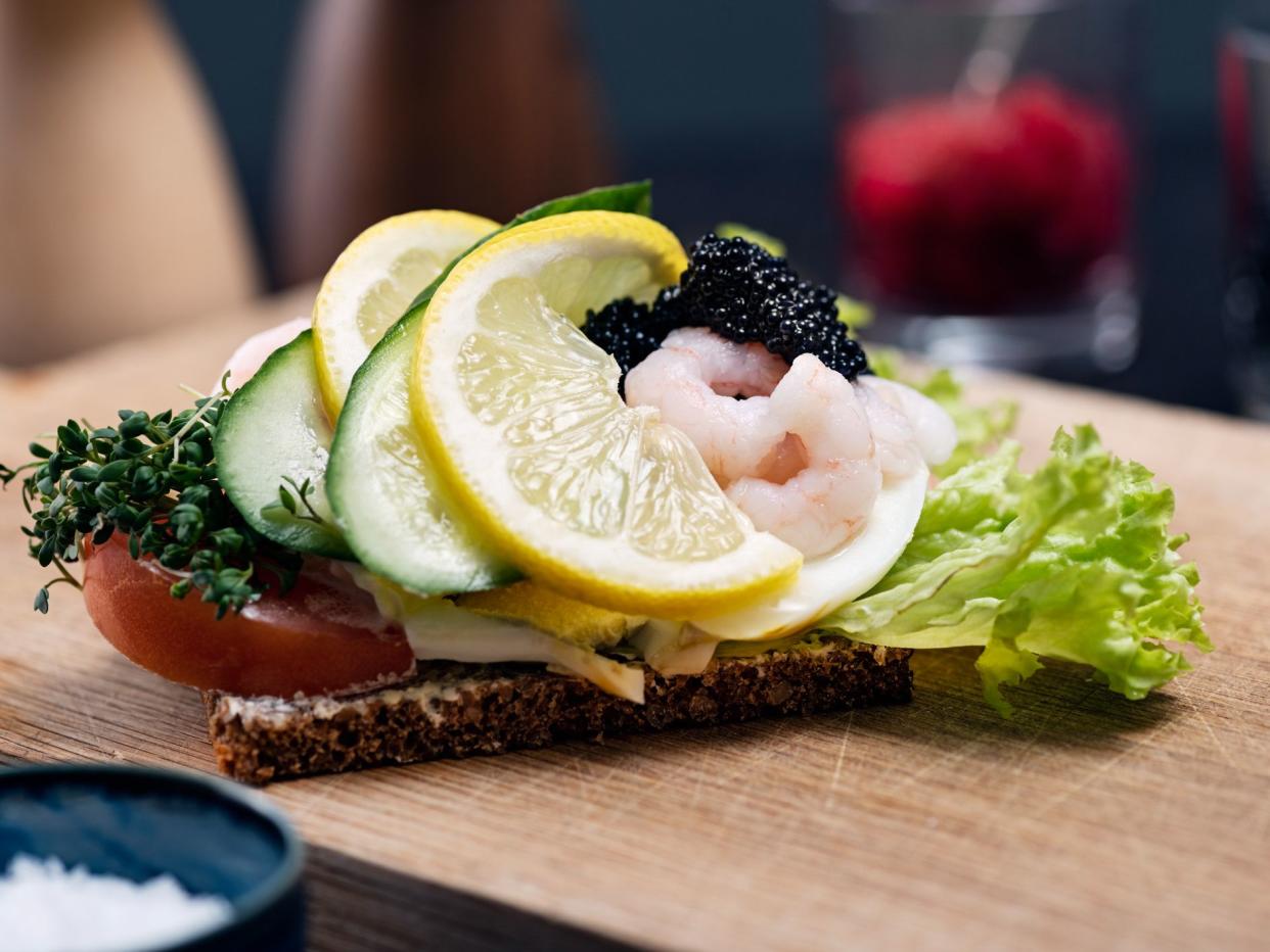 Smørrebrød is a traditional open faced sandwich made with dark rye bread with various cold toppings. Toppings range from egg, smoked fish to cold meats with various pickles and herbs added. Traditionally eaten at lunchtime or occasionally at the end of a 