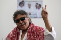 FILE - In this Dec. 6, 2016 file photo, Revolutionary Armed Forces of Colombia, FARC, rebel commander and peace negotiator Seuxis Hernandez, alias Jesus Santrich, flashes a victory hand signal at the end of a press conference in Bogota, Colombia. The Special Peace Tribunal investigating crimes during the country’s long civil conflict announced Wednesday, May 15, 2019, that Hernandez, should not be extradited to the United States on a drug warrant. (AP Photo/Fernando Vergara, File)