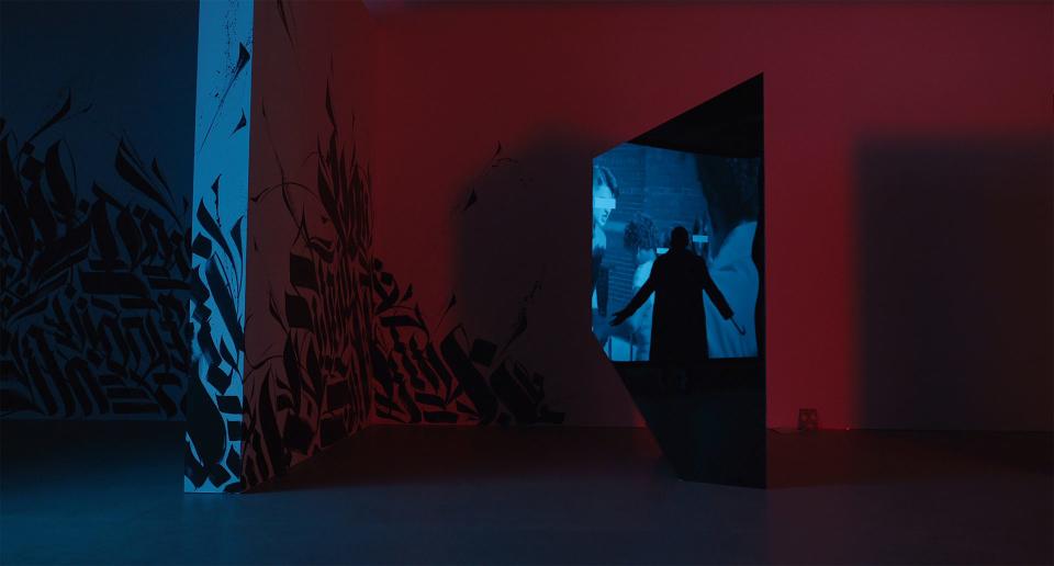 Candyman character stands in art gallery in dark with flashes of red and blue lights