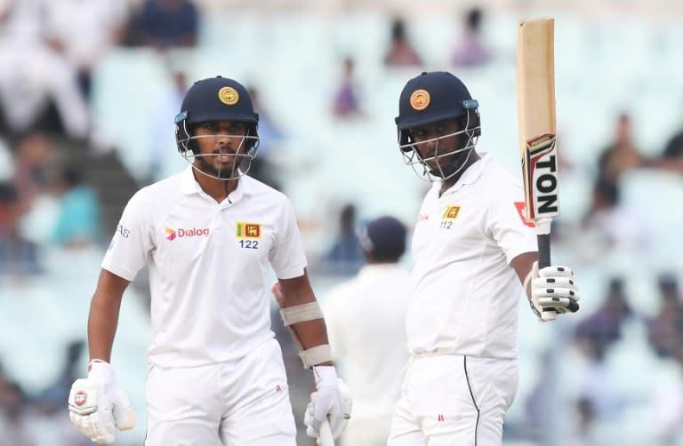 Sri Lanka's Angelo Mathews celebrates after scoring a half-century (50 runs) as captain Dinesh Chandimal looks on during the third day of the first Test between India and Sri Lanka at the Eden Gardens cricket stadium in Kolkata