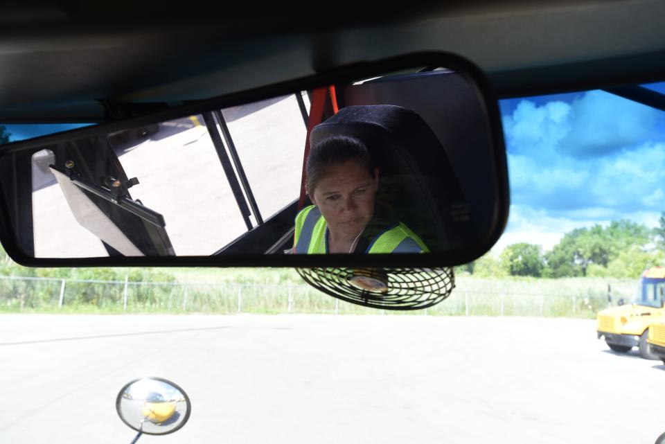 Nancy Whitmore, a school bus driver and trainer for the Port Huron School District, 
checks her side mirrors before driving during a training exercise at the Port Huron Area School District Bus Depot on Thursday, August 11, 2022.