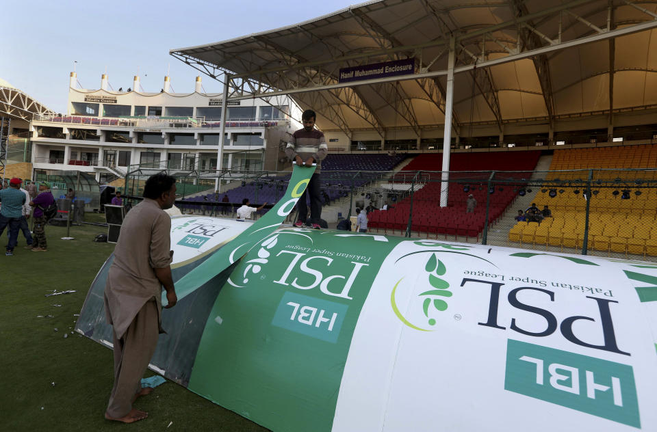 In this Monday, Feb. 17, 2020, photo, workers decorate an enclosure at National stadium in preparation for upcoming Pakistan Super League, in Karachi, Pakistan. Security concerns stopped foreign cricketers from touring Pakistan four years ago when the country's premier domestic Twenty20 tournament was launched, forcing organizers to stage the event on neutral turf in the United Arab Emirates. When the 2020 edition of the PSL starts in Karachi on Thursday, Darren Sammy of the West Indies and Shane Watson of Australia will be among 36 foreign cricketers involved in the six franchises. (AP Photo/Fareed Khan)