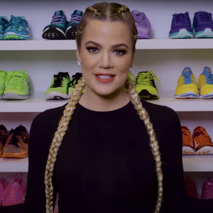 Khloé stands in front of shelves of colorful sneakers