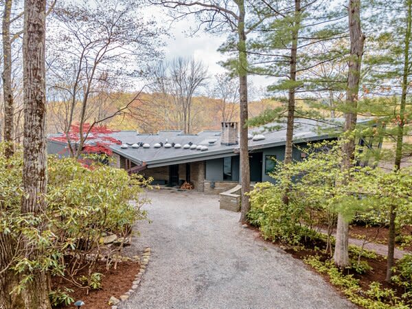 The geometric home offers plenty of privacy, as it sits off the road nestled on a nearly five-acre lot and surrounded by soaring trees.