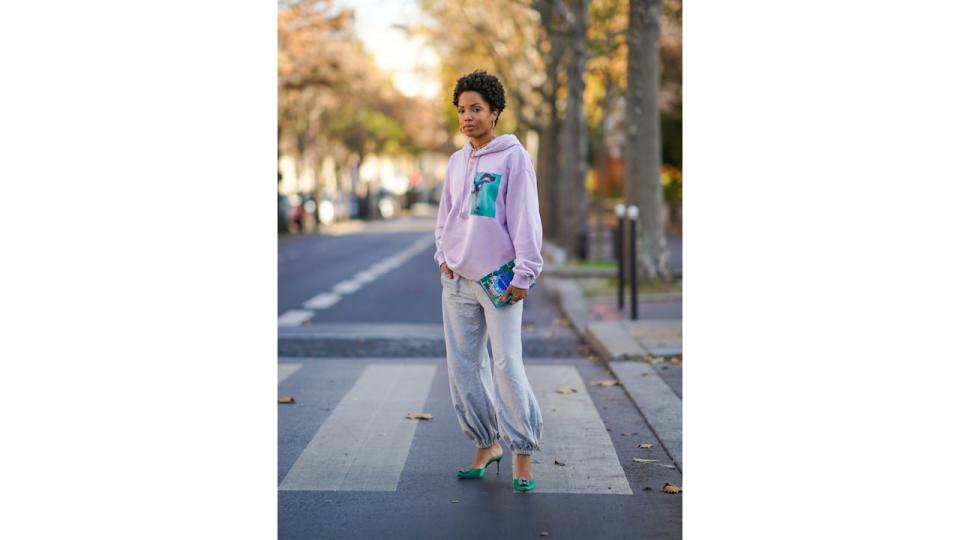 Ellie Delphine pairs her gray sweatpants from Norma Kamali with a clutch from Olympia Le Tan