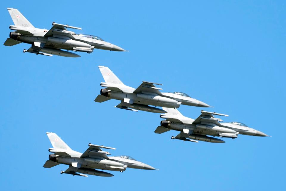 Four F-16 fighter jets in the sky above the Polish capital