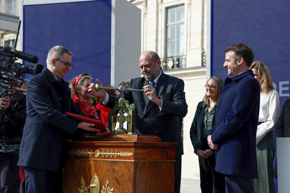 French President Emmanuel Macron, right, and Justice Minister Eric Dupond-Moretti, center, attend a ceremony to seal the right to abortion in the French constitution, on International Women's Day, at the Place Vendome, in Paris, France March 8, 2024. France inscribed the guaranteed right to abortion in its constitution Friday, a powerful message of support for women's right on International Women's Day. (Gonzalo Fuentes/Pool Photo via AP)