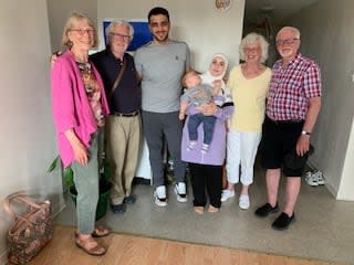 Mohammad Al-Fadle and his family (middle) stand with members of their sponsorship group, including Martin Low to the left of him. 