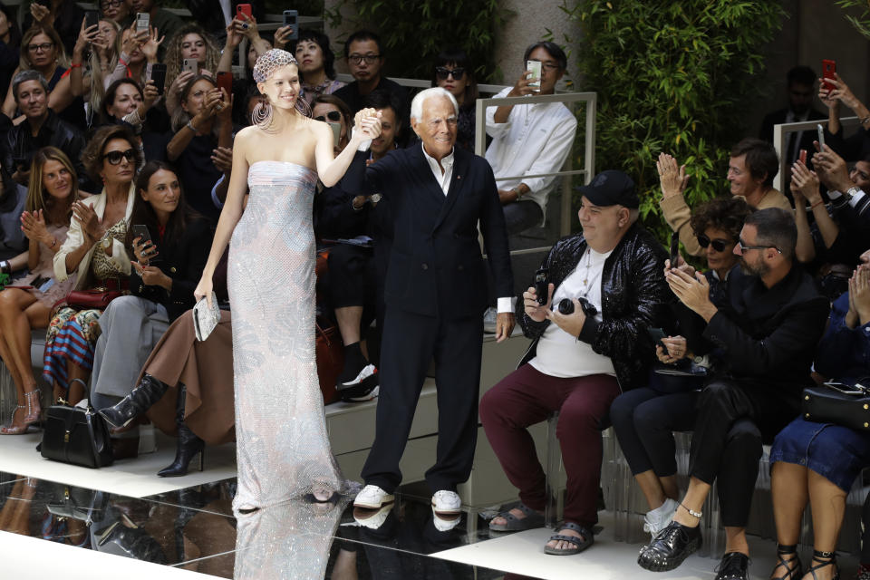 Designer Giorgio Armani, center right, poses with a model as he accepts applause at the conclusion of the Armani Spring-Summer 2020 collection, unveiled during the fashion week, in Milan, Italy, Saturday, Sept. 21, 2019. (AP Photo/Luca Bruno)