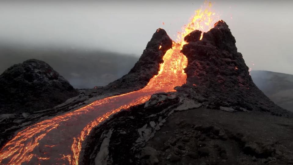 Up-close drone footage of a river of lava coming down from an active volcano that is still erupting