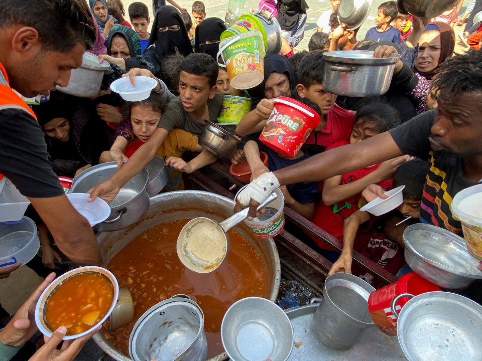 Palestinians recieving food in Rafah (REUTERS)