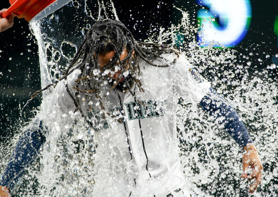 Seattle Mariners' J.P. Crawford is doused by teammate Ty France after driving in the tying and winning runs with a double against the Texas Rangers during the ninth inning of a baseball game Thursday, Sept. 28, 2023, in Seattle. (AP Photo/Lindsey Wasson)