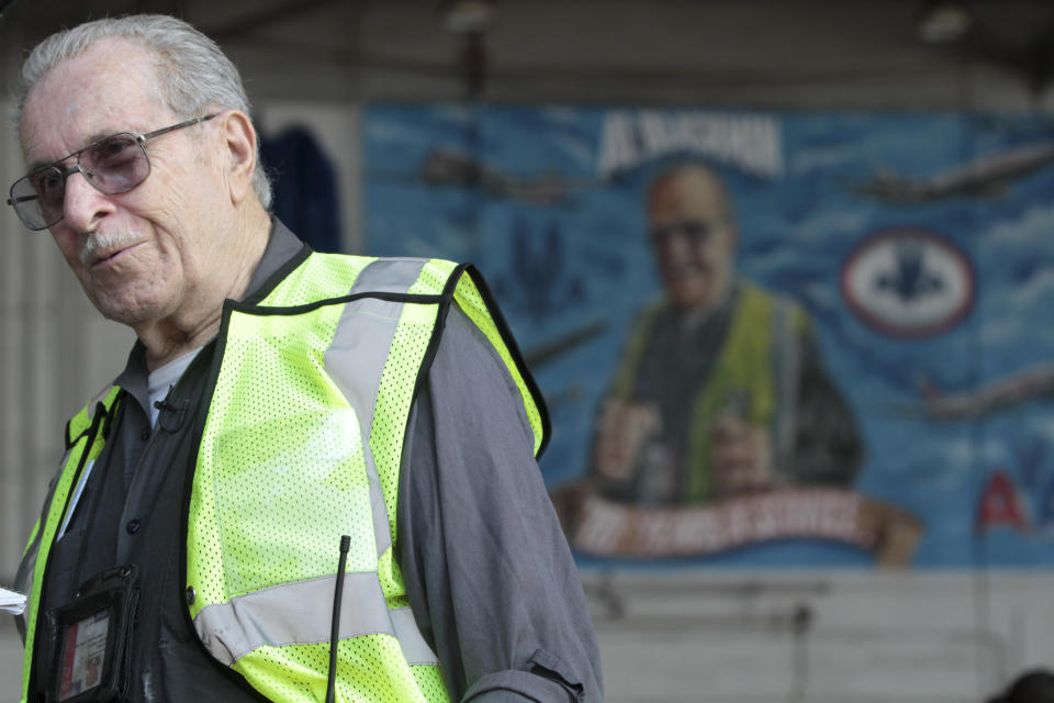 Azriel "Al" Blackman is framed by a mural of him in Hanger 10 while speaking to reporters at John F. Kennedy International Airport,  Wednesday, July 18, 2012 in New York.  American Airlines is celebrating the 70-year service of a New York City mechanic who says he has no plans to retire. Azriel "Al" Blackman was 16 years old when he started as an apprentice mechanic in July of 1942. (AP Photo/Mary Altaffer)