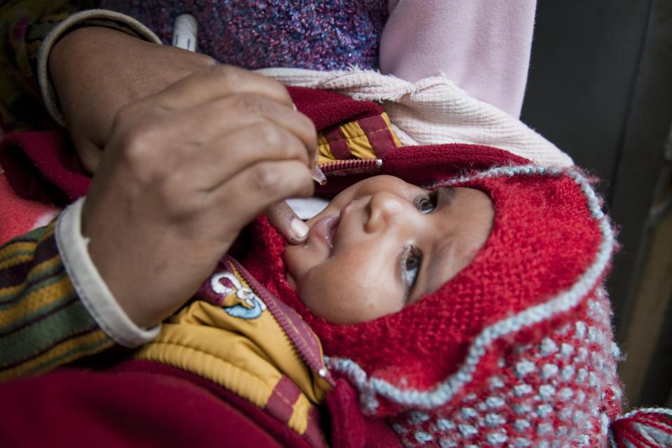 A child receives oral polio vaccine from a house-to-house polio vaccination team in the Kamla Nehru Nagar slum in Patna. (PHOTO: Bill & Melinda Gates Foundation/Prashant Panjiar)  