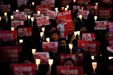 People chant slogans during a protest calling for South Korean President Park Geun-hye to step down in central Seoul, South Korea, November 29, 2016. The sign reads "Step down Park Geun-hye immediately". REUTERS/Kim Hong-Ji