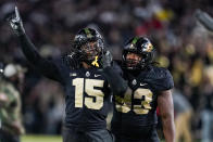 Purdue defensive end DaMarcus Mitchell (15) and defensive tackle Prince Boyd Jr. (93) celebrate as they defeat Michigan State in an NCAA college football game in West Lafayette, Ind., Saturday, Nov. 6, 2021. (AP Photo/Michael Conroy)