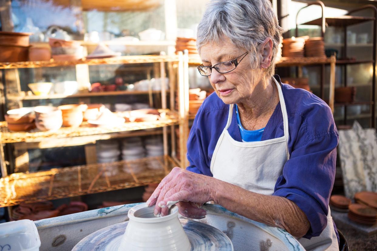 senior woman potter making pot in pottery workshop