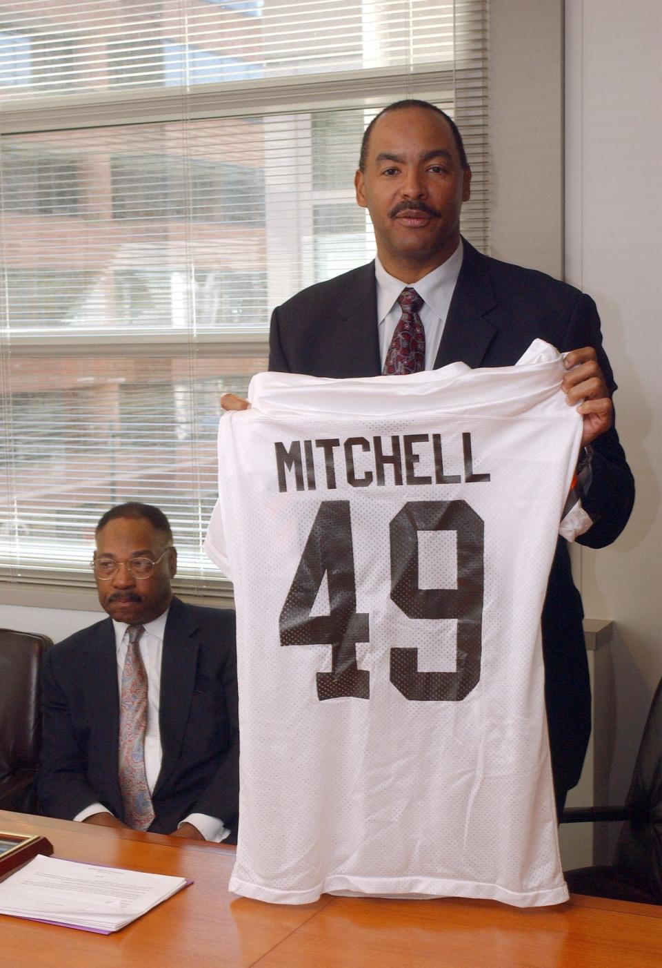 Former Washington assistant general manager Bobby Mitchell, left, looks on as fellow Hall of Famer Kellen Winslow, former executive director of the Fritz Pollard Alliance, holds a "Bobby Mitchell, number 49" jersey during a Washington news conference Friday, March 14, 2003.