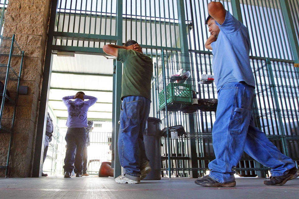 FILE - In this Aug. 9, 2012, file photo, suspected illegal immigrants are transferred out of the holding area after being processed at the Tucson Sector of the U.S. Customs and Border Protection headquarters in Tucson, Ariz. A years-old lawsuit challenging detention conditions in several of the Border Patrol’s Arizona stations will go to trial Monday, Jan. 13, 2020, as the agency as a whole has come under fire following several migrant deaths. The lawsuit was first filed in June 2015 and applies to eight Border Patrol facilities in Arizona where attorneys say migrants are held in unsafe and inhumane conditions. (AP Photo/Ross D. Franklin, File)