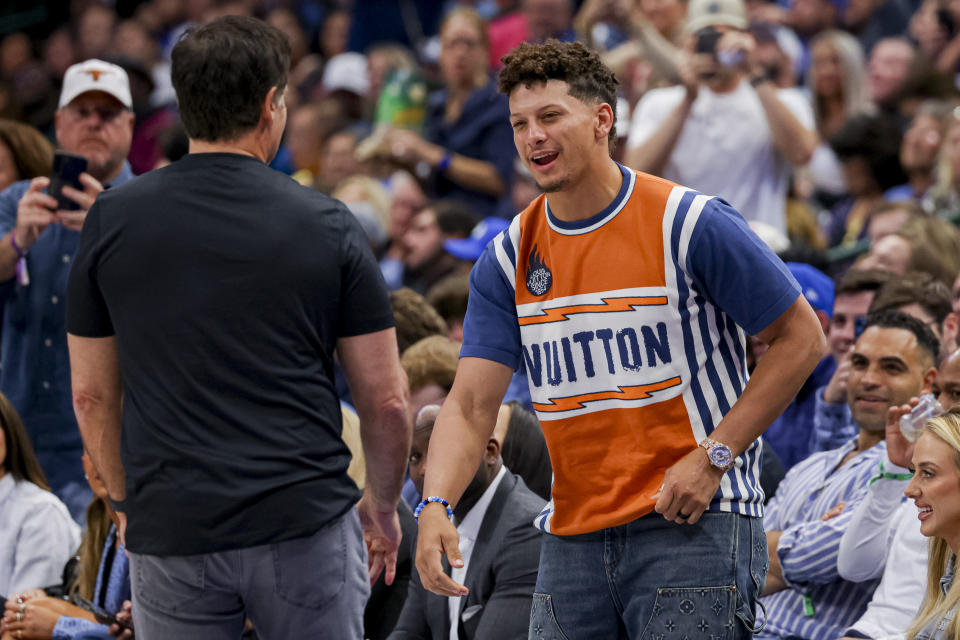 Dallas Mavericks owner Mark Cuban, left, talks with Kansas City Chiefs quarterback Patrick Mahomes, right, during the second half of an NBA basketball game between the Dallas Mavericks and Toronto Raptors, Wednesday, Nov. 8, 2023, in Dallas. (AP Photo/Gareth Patterson)