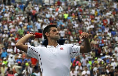 Novak Djokovic of Serbia throws his wrist band into the crowd after defeating to Philipp Kohlschreiber of Germany at the 2014 U.S. Open tennis tournament in New York, September 1, 2014. REUTERS/Eduardo Munoz