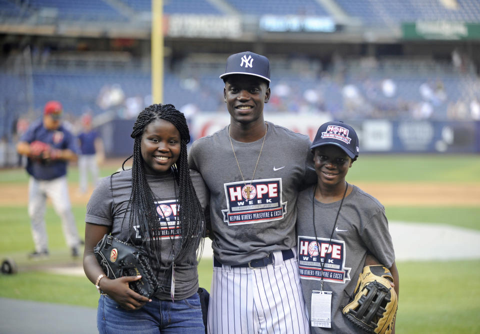 FILE - In this Monday, Aug. 17, 2017, Chris Singleton poses with his sister, Camryn, left, and his brother, Caleb, right, before the New York Yankees and Minnesota Twins baseball game at Yankee Stadium in New York. The Chicago Cubs have drafted Chris Singleton, whose mother was among those killed two years ago during the shooting inside a South Carolina church. Singleton was selected Wednesday by the defending World Series champions with the final pick of the 19th round, No. 585 overall. He is a right-handed-hitting center fielder at Charleston Southern University. (AP Photo/Bill Kostroun, File)