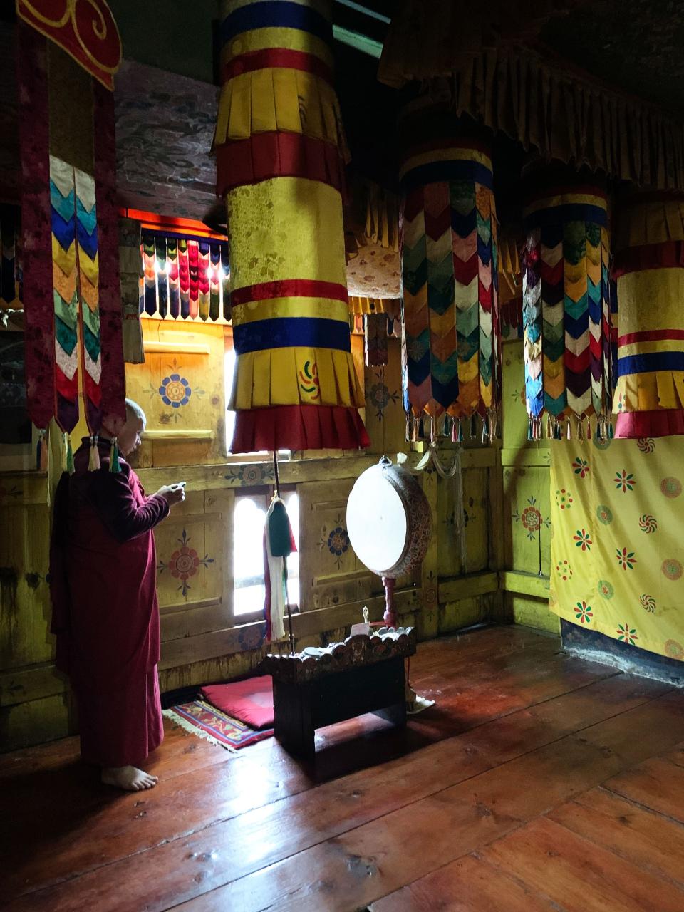 The shrine's altar, with the elaborate fabric hangings known as gyeltshens, which are typical of Buddhist altars. The blue pine floor is original.