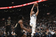 Dallas Mavericks' Luka Doncic (77) shoots as Toronto Raptors' Chris Boucher, left, and Thaddeus Young, center, look on during second-half NBA basketball game action in Toronto, Saturday, Nov. 26, 2022. (Chris Young/The Canadian Press via AP)