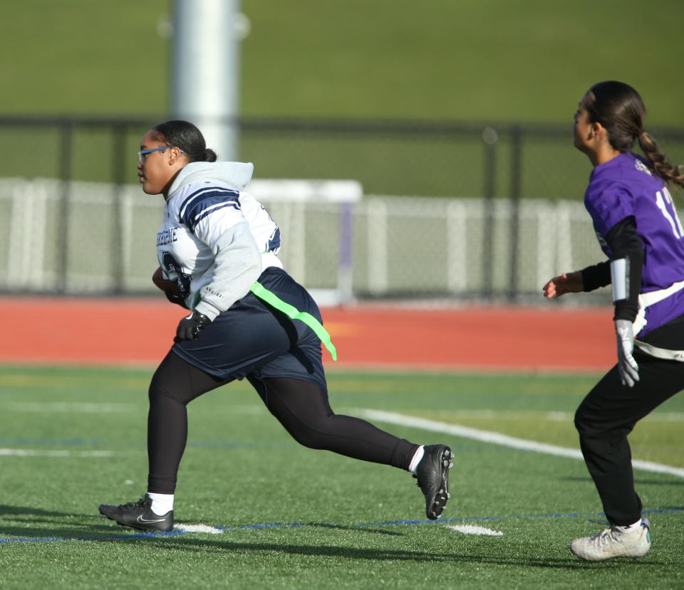 Poughkeepsie's Gabriel Anderson carries for a gain ahead of Monroe-Woodbury's Ariana Torrellas during a game on April 4, 2024.