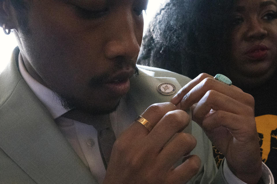 State Rep. Justin Jones, D-Nashville, puts on his legislative pin as he enters the state Capitol, Monday, April 10, 2023, in Nashville, Tenn. Jones was appointed to represent District 52 by the Metro Nashville City Council after being expelled the previous week for using a bullhorn to shout support for pro-gun control protesters in the House chamber. (AP Photo/George Walker IV)