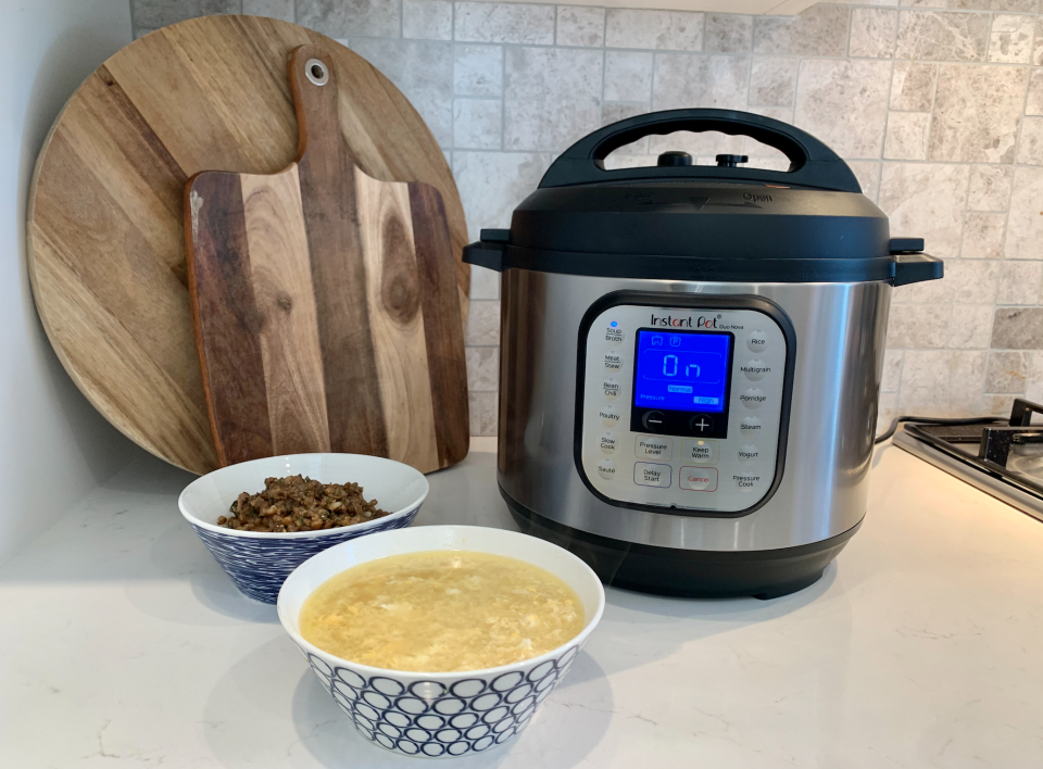 A 5.7L Instant Pot next to a bowl of chicken broth and a bowl of lentils