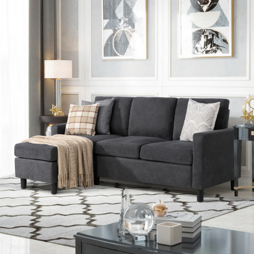 dark grey sofa in living space with decorative pillows and a throw blanket