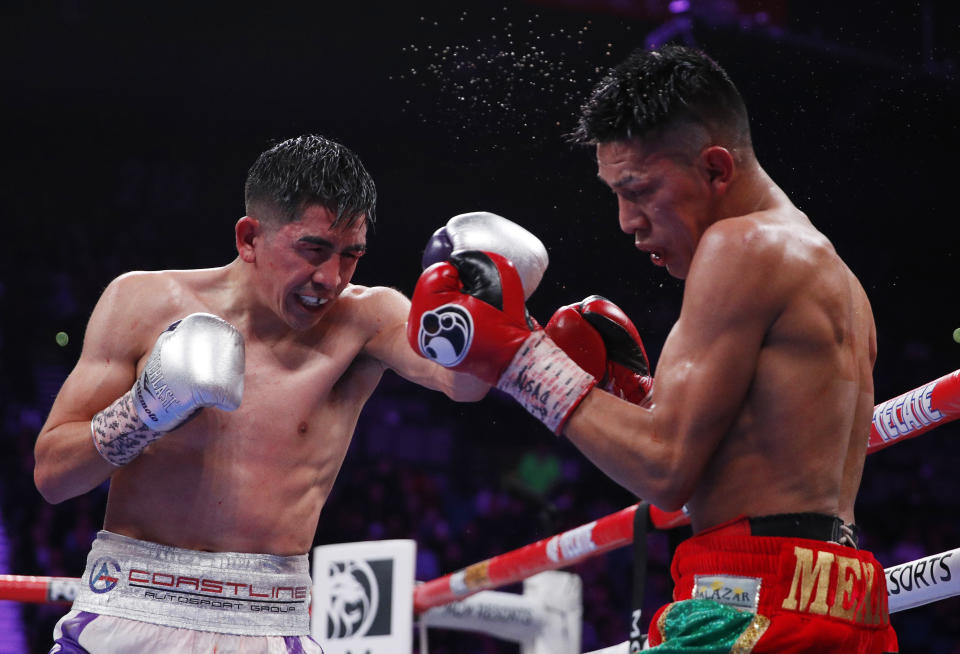 ARCHIVO - En esta foto de archivo del 23 de noviembre de 2019, el mexicano Leo Santa Cruz golpea a su compatriota Miguel Flores durante una pelea por el cetro superpluma de la AMB en Las Vegas (AP Foto/John Locher, archivo)