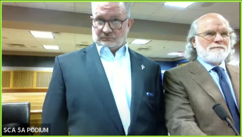 In this image made from video from Judge Scott McAfee's virtual Zoom hearing, Scott Graham Hall, left, stands with his attorney Jeff Weiner, right, in Superior Court of Fulton County before Judge McAfee, not pictured, in Courtroom 5A on Friday, Sept. 29, 2023, in Atlanta. Hall, a bail bondsman charged alongside former President Donald Trump and 17 others in the Georgia election interference case, pleaded guilty to misdemeanor charges on Friday, becoming the first defendant to accept a plea deal with prosecutors. (USA Today via AP, Pool)