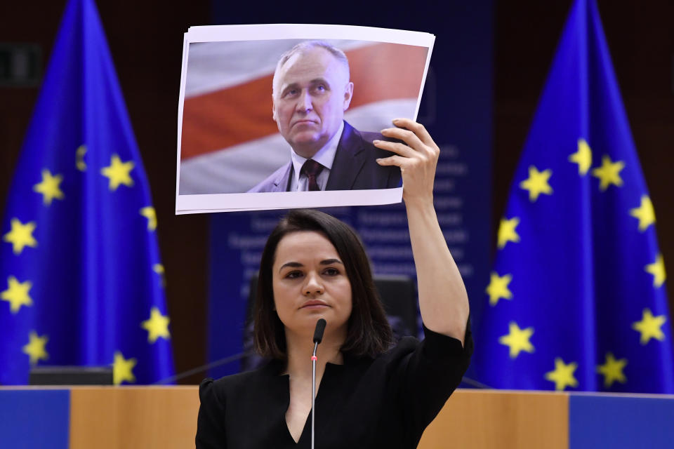Belarusian opposition politician Sviatlana Tsikhanouskaya holds a picture of Belarusian politician Mikalai Statkevich as she gives a speech during the Sakharov Prize ceremony at the European Parliament in Brussels, Wednesday, Dec. 16, 2020. The European Union has awarded its top human rights prize to the Belarusian democratic opposition. (John Thys/Pool Photo via AP)