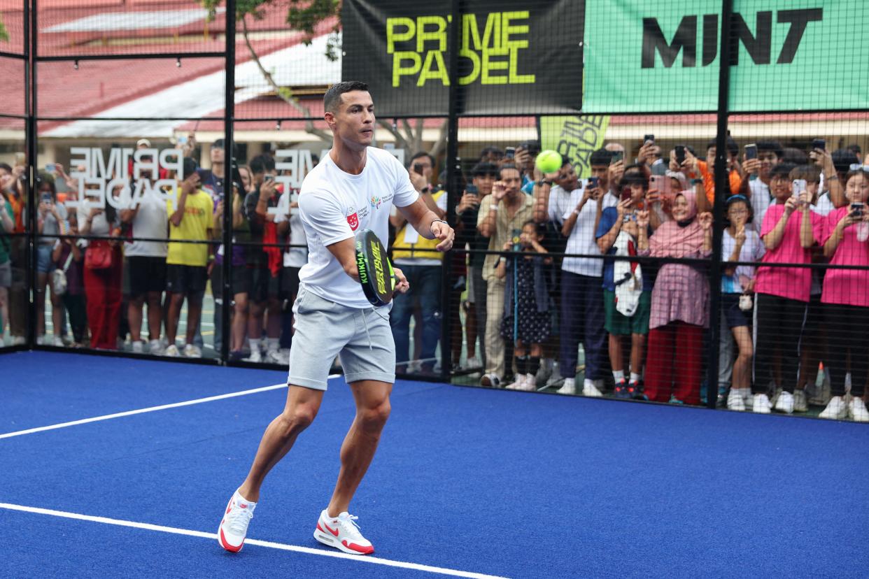 Football superstar Cristiano Ronaldo hits a padel ball during an event to support youth scholarships founded by philanthropist Peter Lim in Singapore.