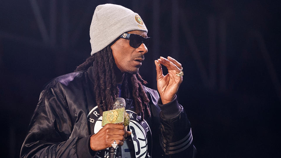 Snoop Dogg performs with a small joint in hand. 