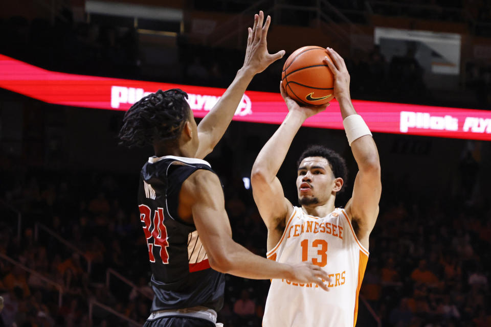 Tennessee forward Olivier Nkamhoua (13) shoots over Austin Peay forward Jalen Ware (24) during the second half of an NCAA college basketball game Wednesday, Dec. 21, 2022, in Knoxville, Tenn. (AP Photo/Wade Payne)