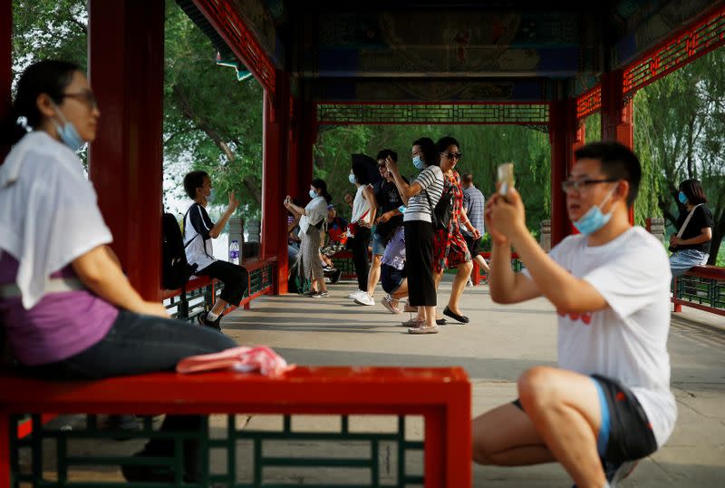 People take pictures in the park at Summer Palace on a public holiday, after a new outbreak of the coronavirus disease (COVID-19), in Beijing