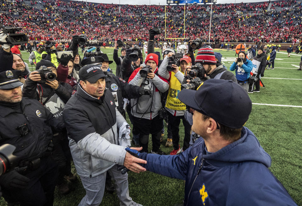 Ohio State head coach Ryan Day, front left, shakes hands with Michigan head coach Jim Harbaugh, front right, after an NCAA college football game in Ann Arbor, Mich., Saturday, Nov. 30, 2019. Ohio State won 56-27. (AP Photo/Tony Ding)