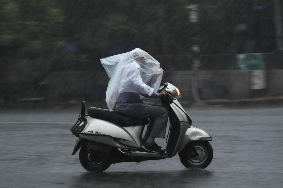 A motorist driving with a plastic sheet for cover during rain at sector 19, on July 19, 2020 in Noida, India. Moderate-to-heavy rain lashed several states in northern, eastern and coastal India on Sunday, but the monsoon activity continued to remain subdued in Delhi, which has recorded a 40 per cent rainfall deficiency despite an early onset of the seasonal weather system. (Photo By Sunil Ghosh/Hindustan Times via Getty Images)