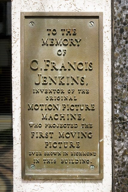 This plaque commenorates 726 East Main as the place where the first-reported audience witnessed moving pictures projected by light on a screen.