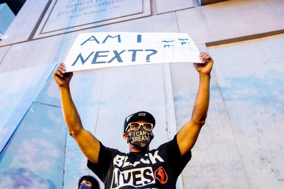 Romeo Ceasar holds a sign during a Black Lives Matter protester on Monday, July 20, 2020, in Portland, Oregon.